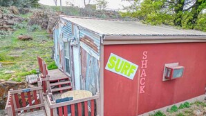 A red shack with a 'SURF' sign and a wooden deck leading to it. - Surf Shack at Triple Z (Medicine Park)