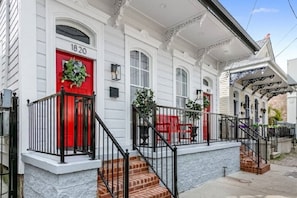 A white building with a red door and the number 1820. - Spacious 6BR Hideaway: Minutes to French Quarter (New Orleans)