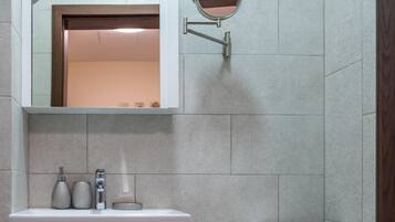 Ein Badezimmer mit einer weißen Toilette, einem Waschbecken mit Spiegel darüber und einem Handtuchhalter an der Wand.