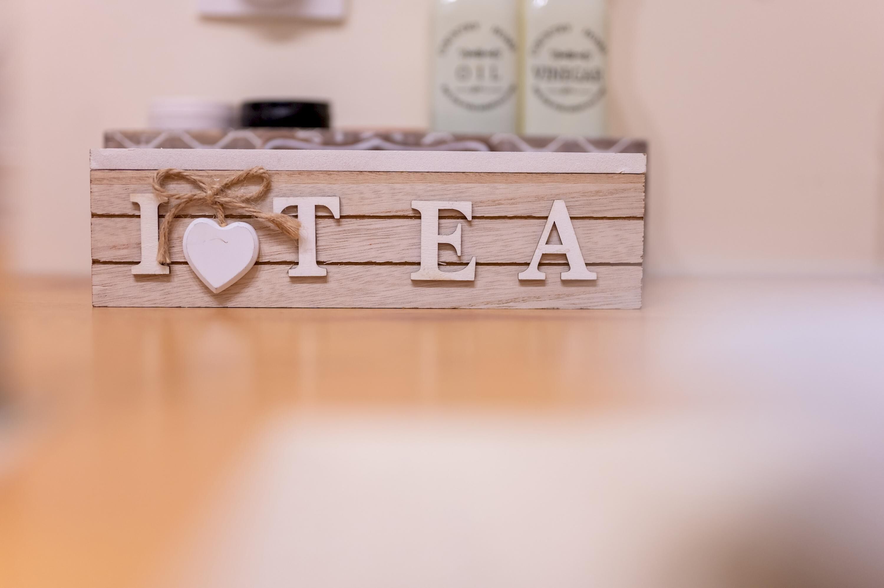 A wooden block with the letters "I HEART TEA" and a heart-shaped decoration.