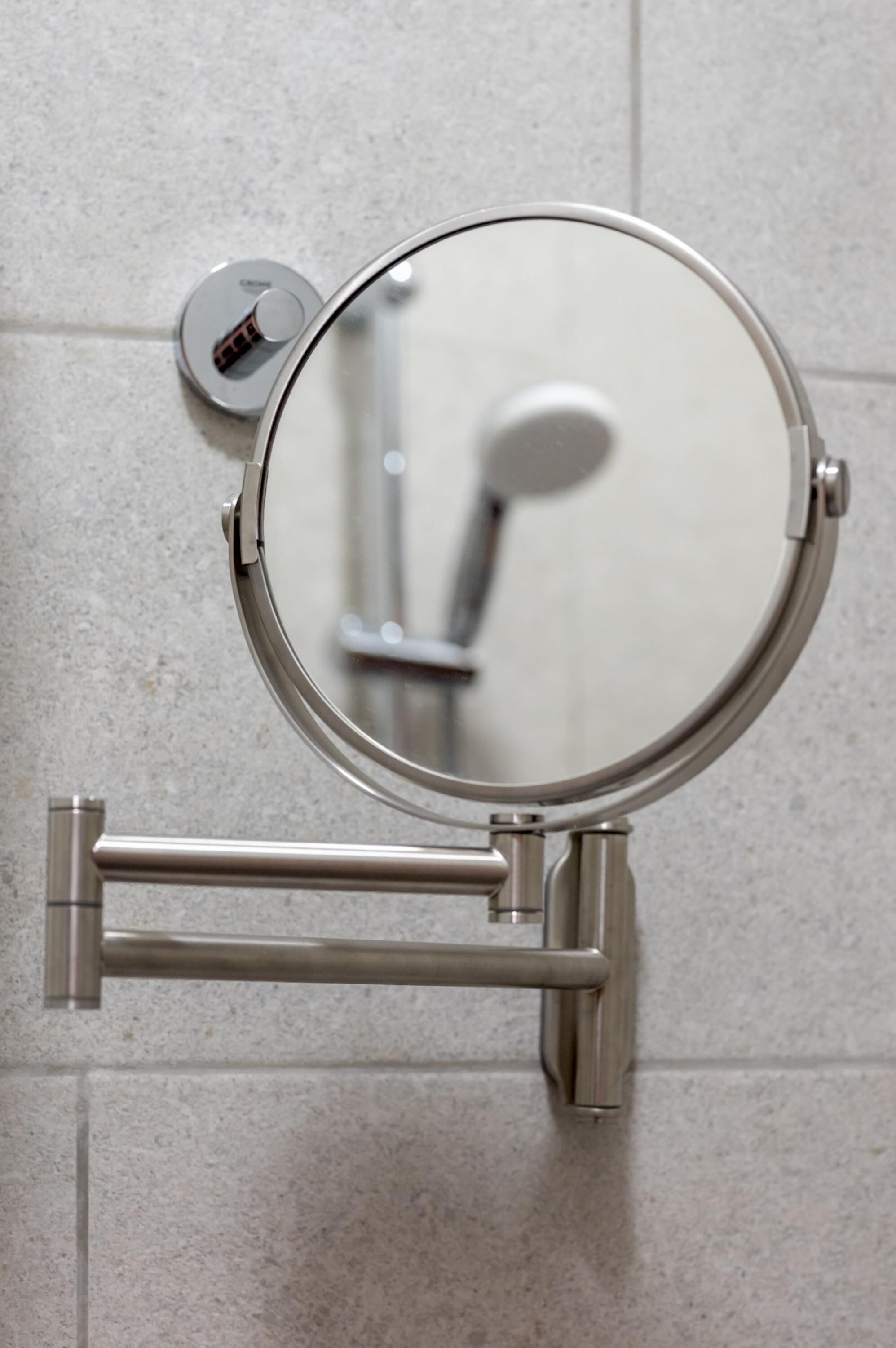 Des toilettes dotées d’un miroir rond et d’un accessoire de type bidet.