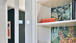 A room with a white bookshelf, a patterned wall, and a door leading to another room. - THE GOOD PLACE - Walk to Uptown Westerville - 3BR (Westerville)