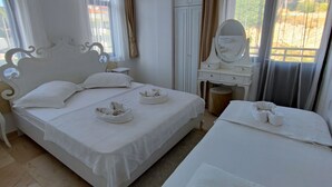 Ein Hotelzimmer mit zwei Betten, einem Schminktisch mit Spiegel und einem kleinen Tisch.