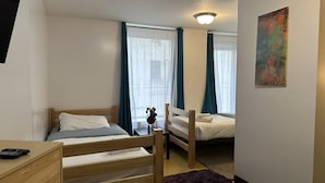A hotel room with two beds, a desk, and a painting on the wall. - Cute Downtown APT Quick Safe Walk to PPG Arena (Pittsburgh)