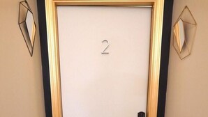 Una porta con il numero 2, una maniglia e un tappetino con la scritta 'LOVE LIFE'.