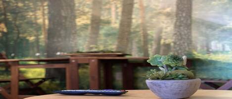 A round wooden table with a remote control and a potted plant.