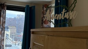 Ein Zimmer mit Blick auf eine Stadtstraße, einem Holzschrank und einer Wanddekoration mit dem Wort "Adventure".