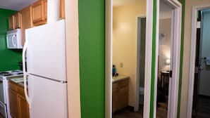 A kitchen with wooden cabinets, a white refrigerator, and a microwave. - Downtown Apt Walk to all Stadiums Conv Center (Pittsburgh)