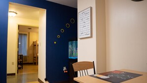 A hotel room with a dining table, a chair, a wall-mounted artwork, and a sign with a message. - 2 Bedroom Downtown Apt Clean and Safe (Pittsburgh)