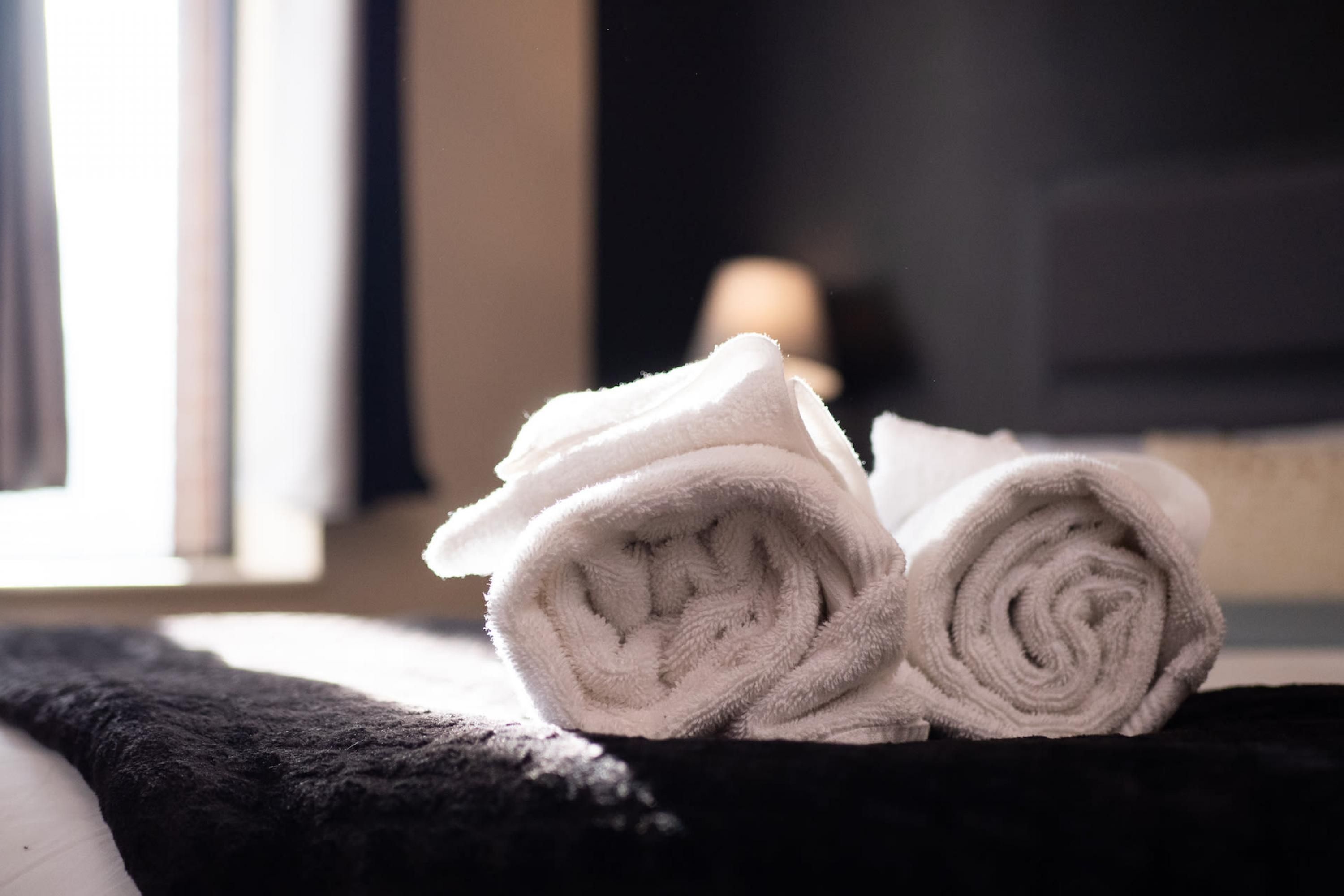 A stack of white towels on a dark surface.