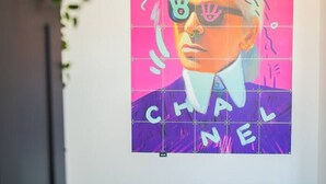 A vibrant poster with a stylized face and the word "CHANEL" on a grid background. - Serviced 1BR Apartments in Utrecht (De Bilt)