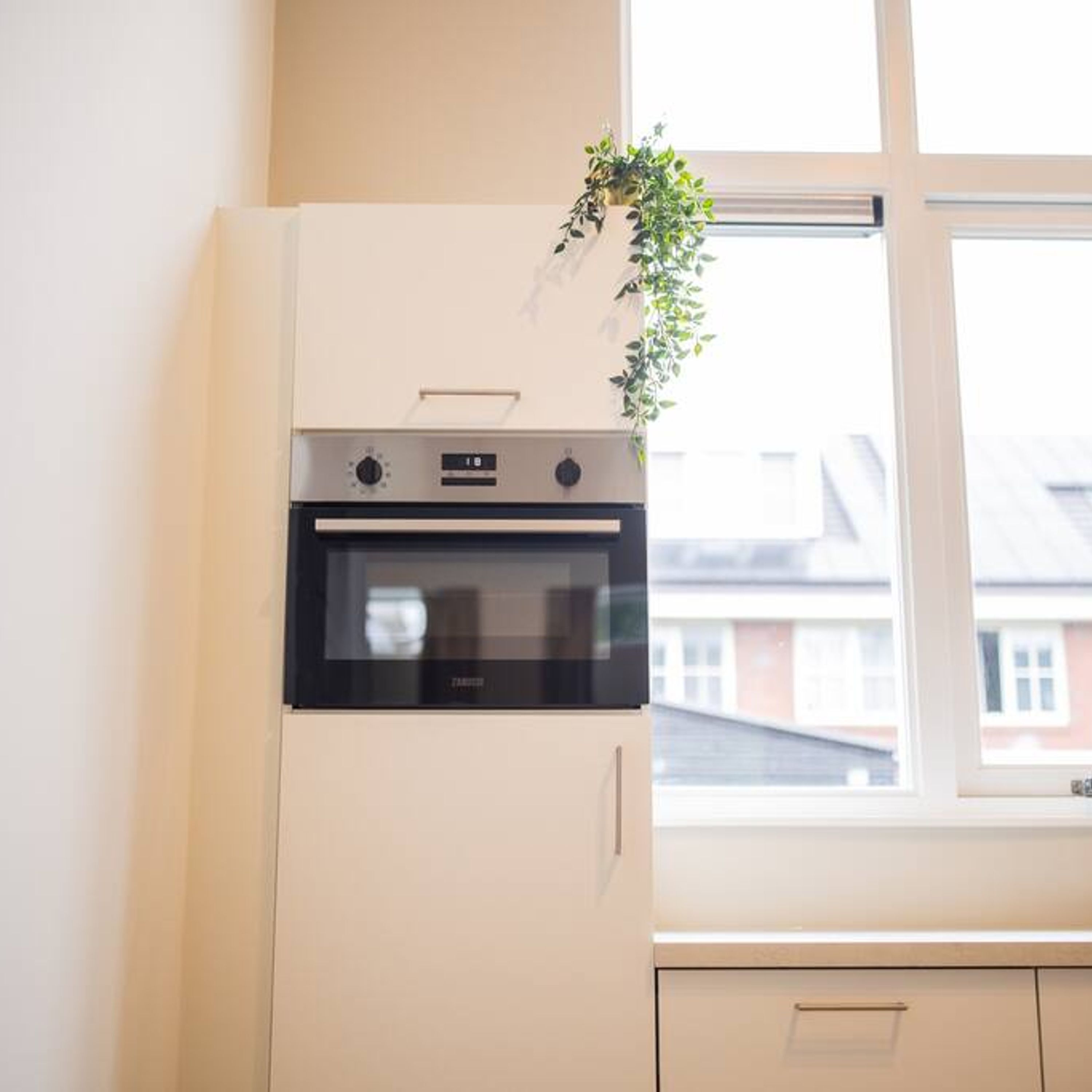 A kitchen with a built-in oven and a window.