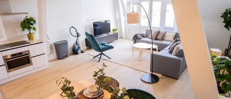 Un apartamento moderno con comedor, cocina, sala de estar y un amplio ventanal.