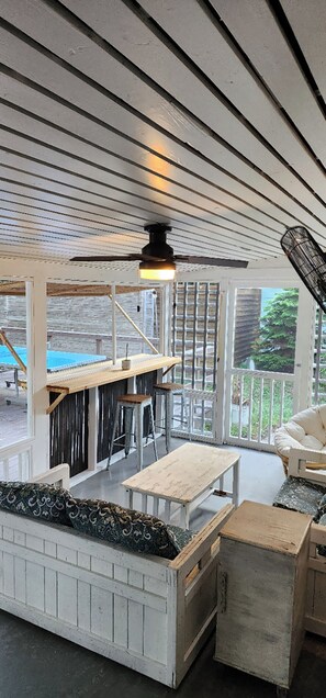 Relax in a cozy seating area with a bench and table, surrounded by natural views through a large window.