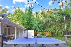 Enjoy casual games and relaxation in this outdoor space with a ping pong table, deck, and covered seating area.