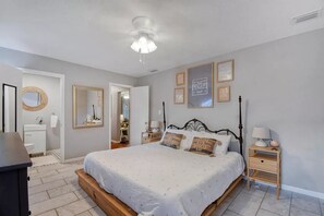 Cozy retreat with a large bed, bedside tables, and a wall-mounted mirror.