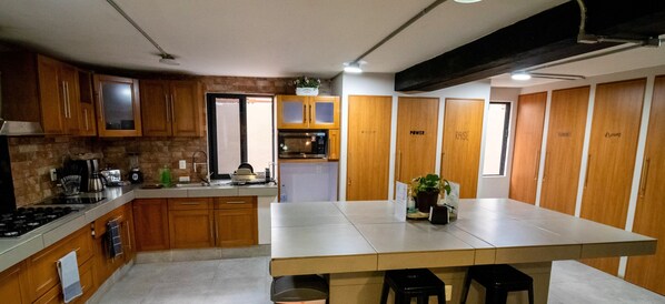 A modern kitchen with wooden cabinets, a central island, and a built-in oven. - R05 Habitación Equipada STV WIFI Parking (Atizapan de Zaragoza)