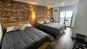 A room with two beds, a brick wall, and a balcony with a view. - R05 Habitación Equipada STV WIFI Parking (Atizapan de Zaragoza)