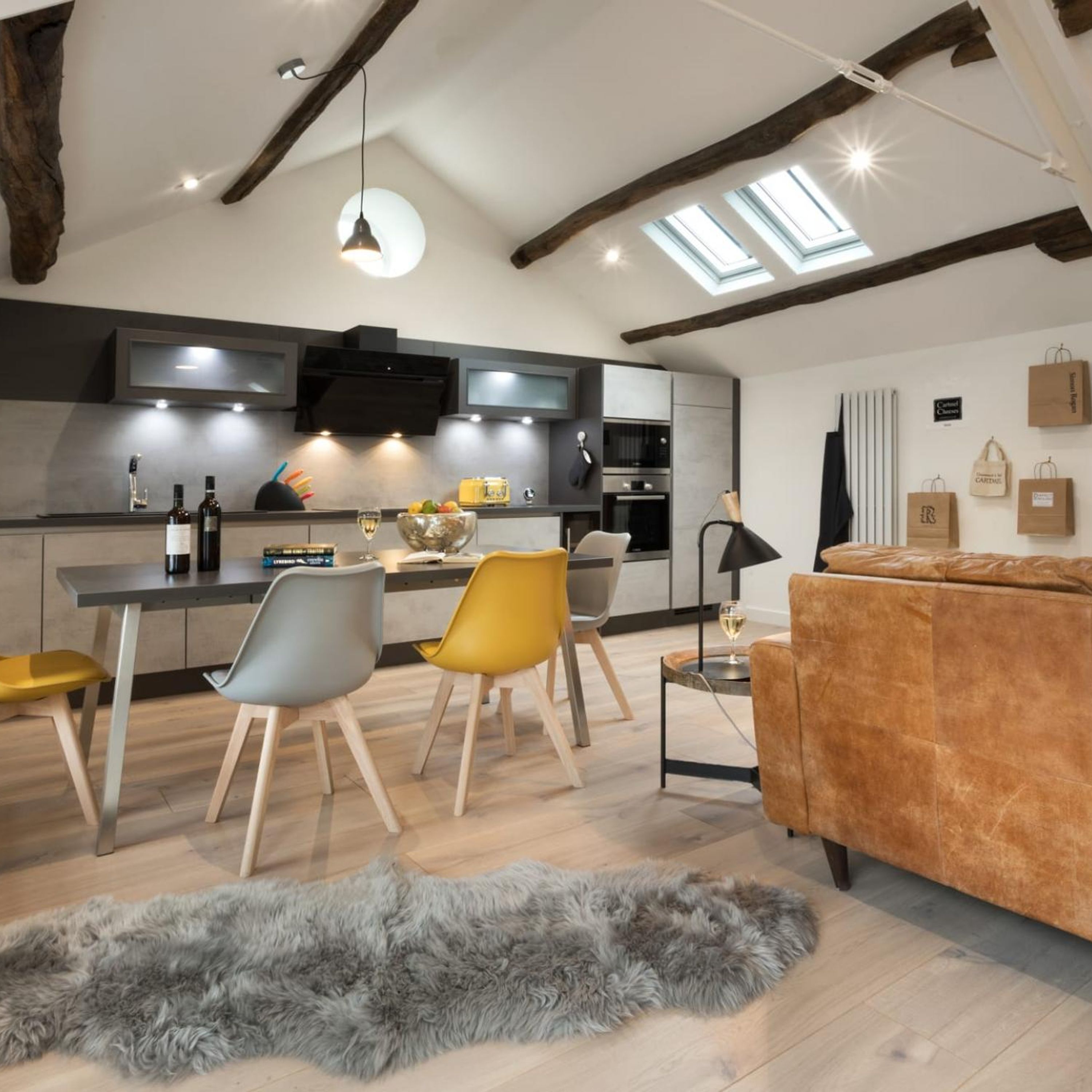 Una cocina moderna con comedor, sofá y una alfombra mullida.