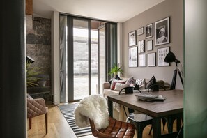 A modern living room with a sofa, a dining table, and a fireplace. - Two-bedroom Apartment at Royal William Yard (Plymouth)
