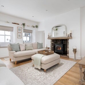 A cozy living room with a fireplace, a sofa, and a coffee table.