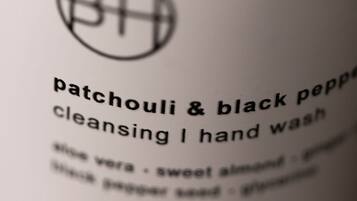 Primer plano de una etiqueta de producto con el texto "patchouli & black pepper cleansing / hand wash" y la lista de ingredientes debajo.