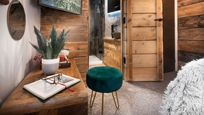 A wooden interior with a wooden bench, a potted plant, a mirror, and a television mounted on the wall. - Windermere Central Hotel - Room 4 (Windermere)