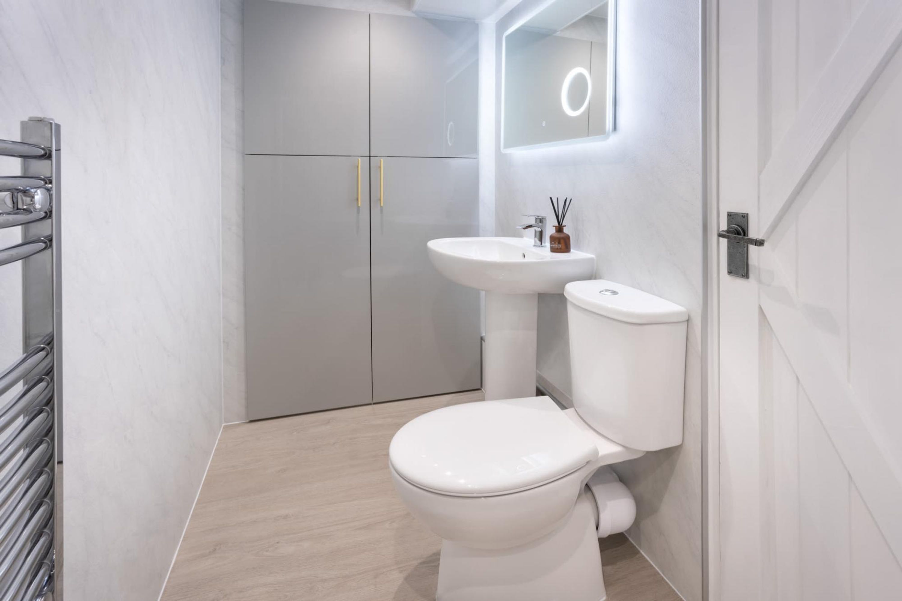A modern bathroom with a white toilet, a sink, and a mirror.