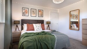 A bedroom with a bed, bedside lamps, a mirror, and wall art. - Scar View - Getaway for Two (Kendal)