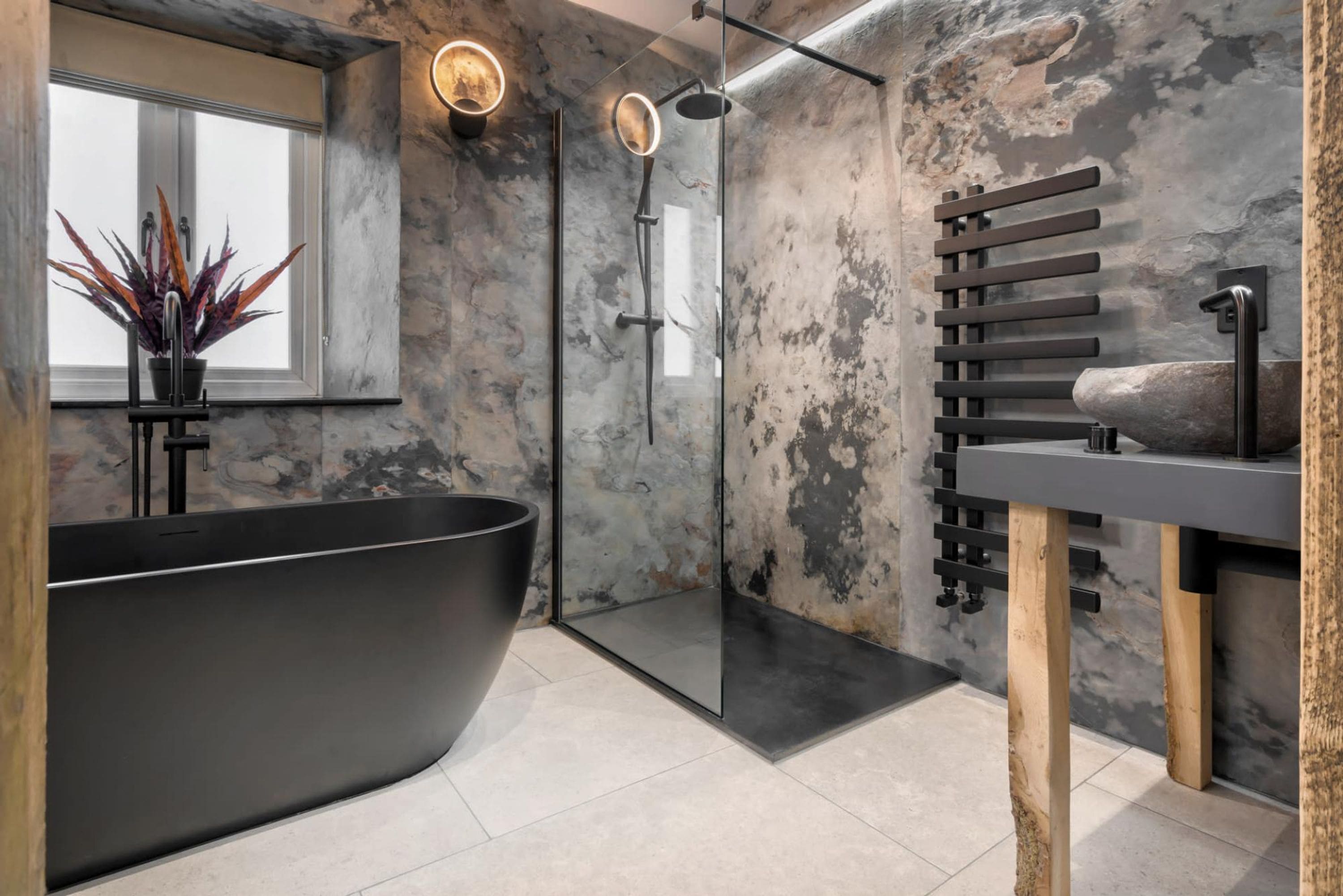 A modern bathroom with a freestanding bathtub, a glass-enclosed shower, and a wooden towel rack.