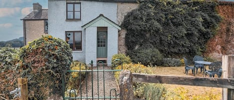 A two-story house with a green door and a small porch.