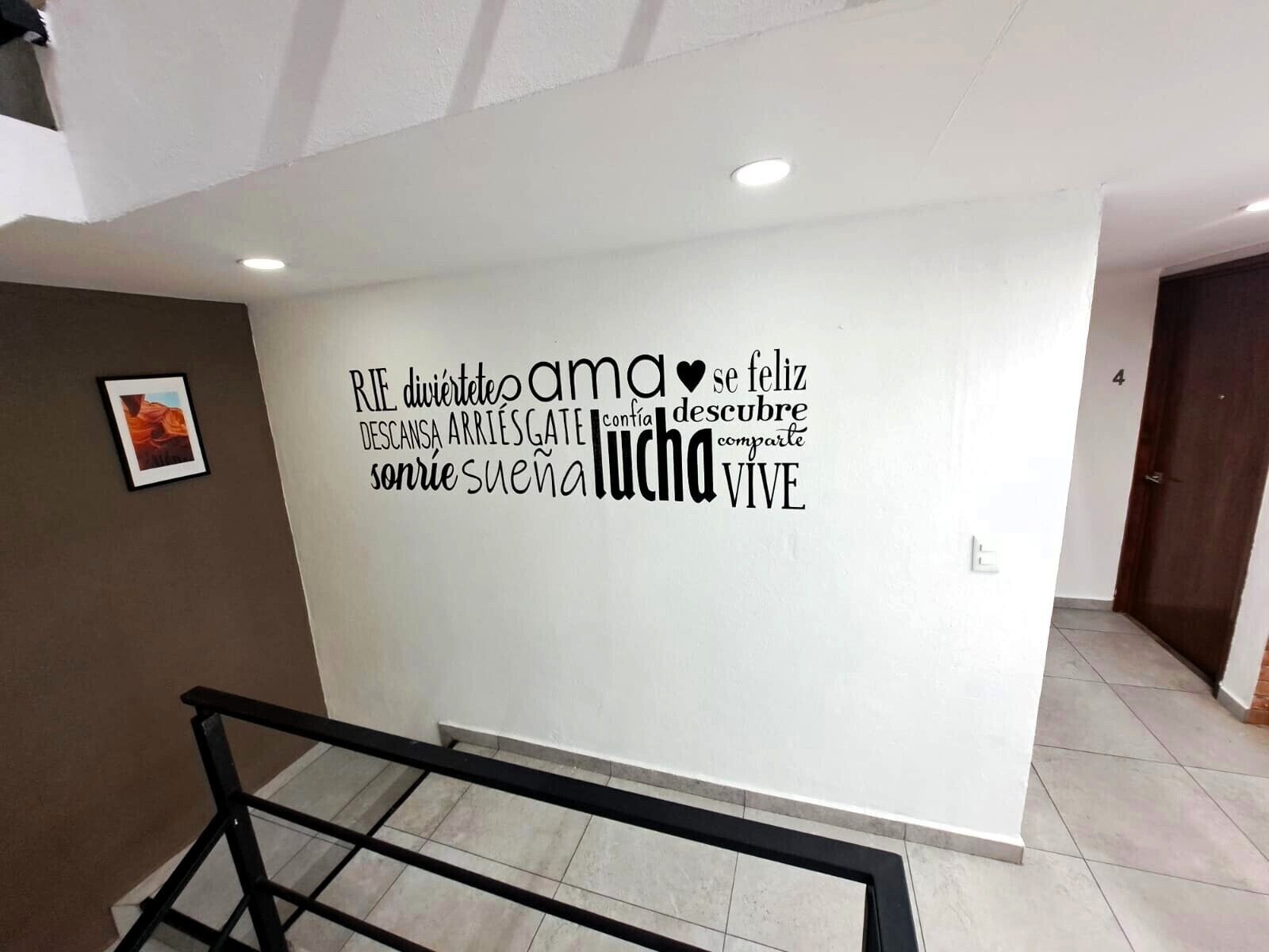 Una pared con texto motivacional y un cuadro enmarcado.