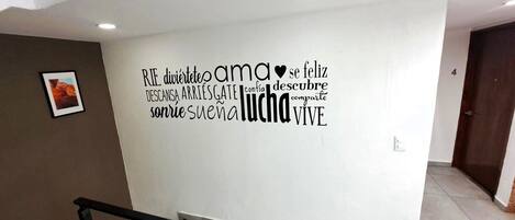 A wall with motivational text and a framed picture.