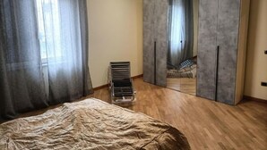A bedroom with a bed, a wardrobe, and a radiator.
