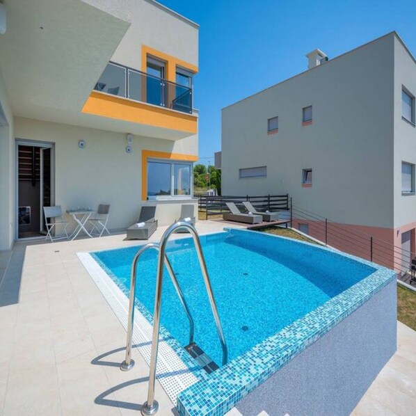 A modern apartment with a swimming pool, outdoor seating, and a balcony. - Villa Magnolija in Pula (Pula)