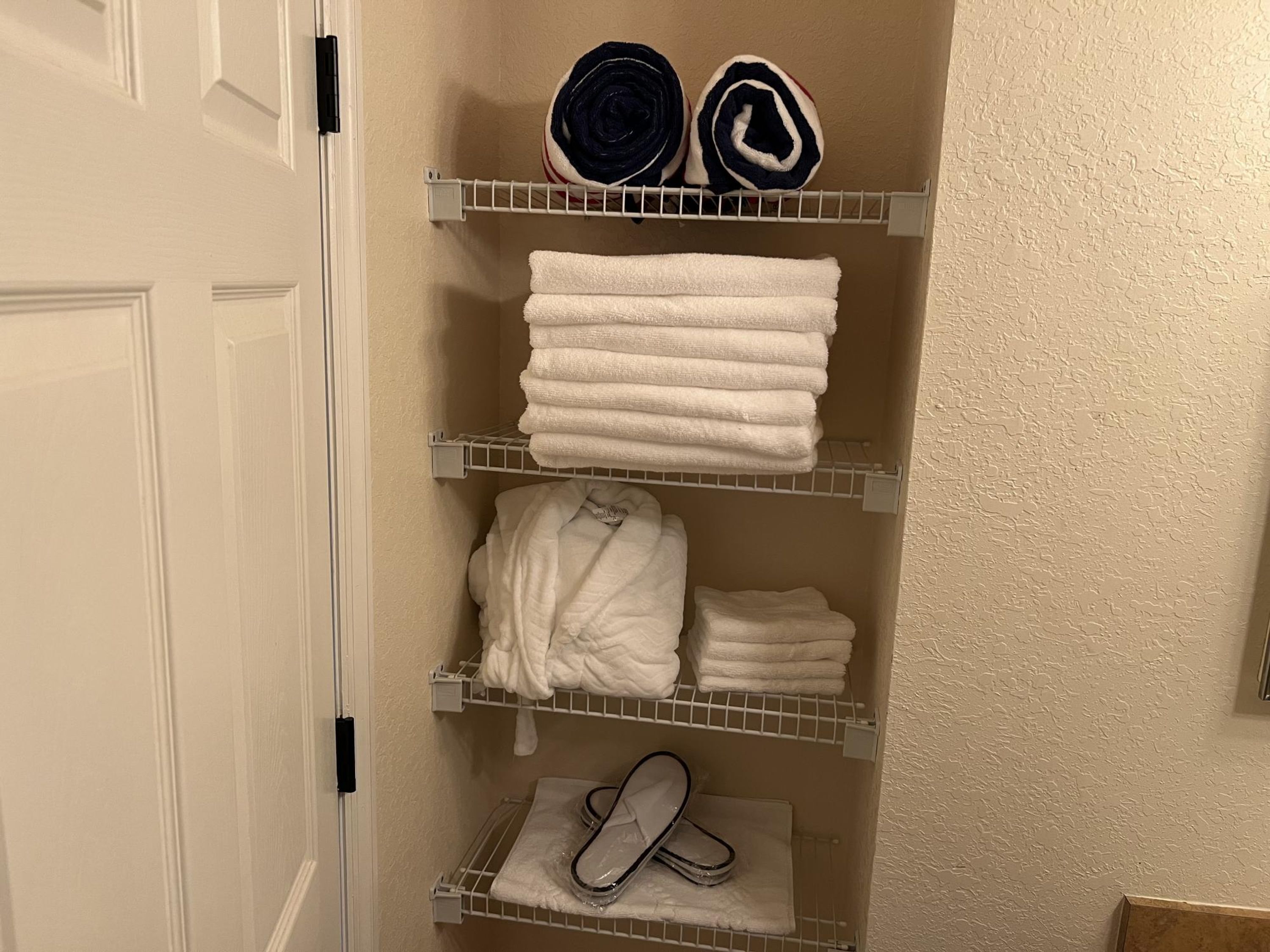 Une salle de bain avec un porte-serviettes sur lequel sont disposées des serviettes pliées et des serviettes enroulées.