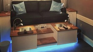 A compact living space with a black sofa, two side-by-side sinks, and a wooden countertop. - Disney Area Resort 3 2 Villa (Davenport)