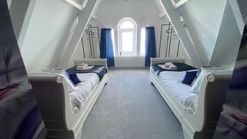 Ein Zimmer mit zwei Betten, einem Oberlicht und Blick ins Freie.