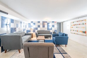 Un salon moderne avec un canapé, des fauteuils et une table basse.