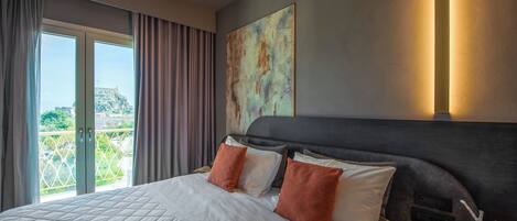 Habitación de hotel con una cama grande, vistas a un balcón y un cuadro en la pared.