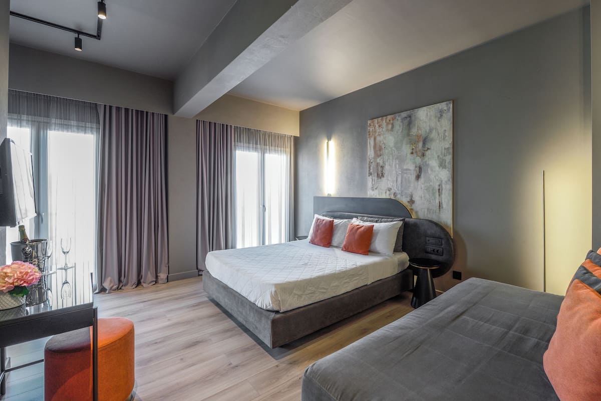 Un dormitorio moderno con una cama grande, un escritorio y un sofá.