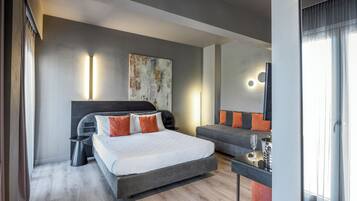 Una habitación de hotel moderna con una cama grande, un escritorio pequeño y un sofá.