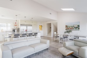 A modern kitchen with white cabinetry, a central island, and pendant lighting. - Spacious and Bright 5-bedroom Oasis Pool and Yard (La Mesa)