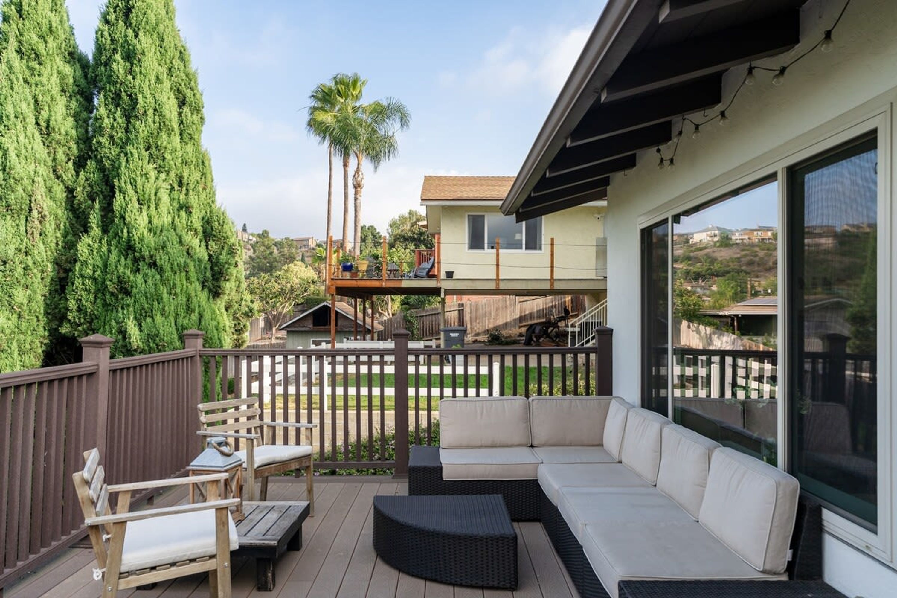 A covered outdoor patio with a sofa, chairs, and a small table.