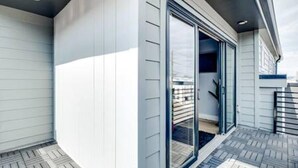 A modern building with a curved exterior wall, a glass door entrance, and a wooden deck. - Music Fame House Gulch 4 Patios View Karaoke (Nashville)