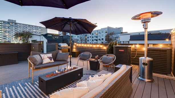 A rooftop patio with outdoor furniture, a heater, and string lights. - Nash Chic Near DT Rooftop Luxe Comfort (Nashville)