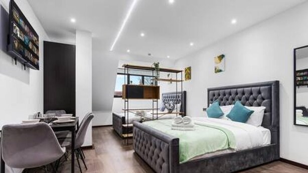A modern bedroom with a large bed, a desk, and a chair. - Modern Spacious Suite Sleeps 4 in Central London (London)