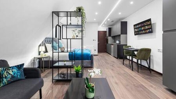 A modern apartment with a bed, a sofa, a dining area, and a kitchen. - Luxury Spacious 2 Person Suite in North London (London)