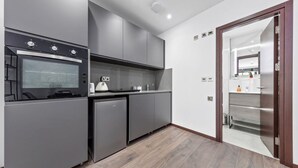Eine moderne Küche mit grauen Schränken, einem eingebauten Ofen und einem Kühlschrank.
