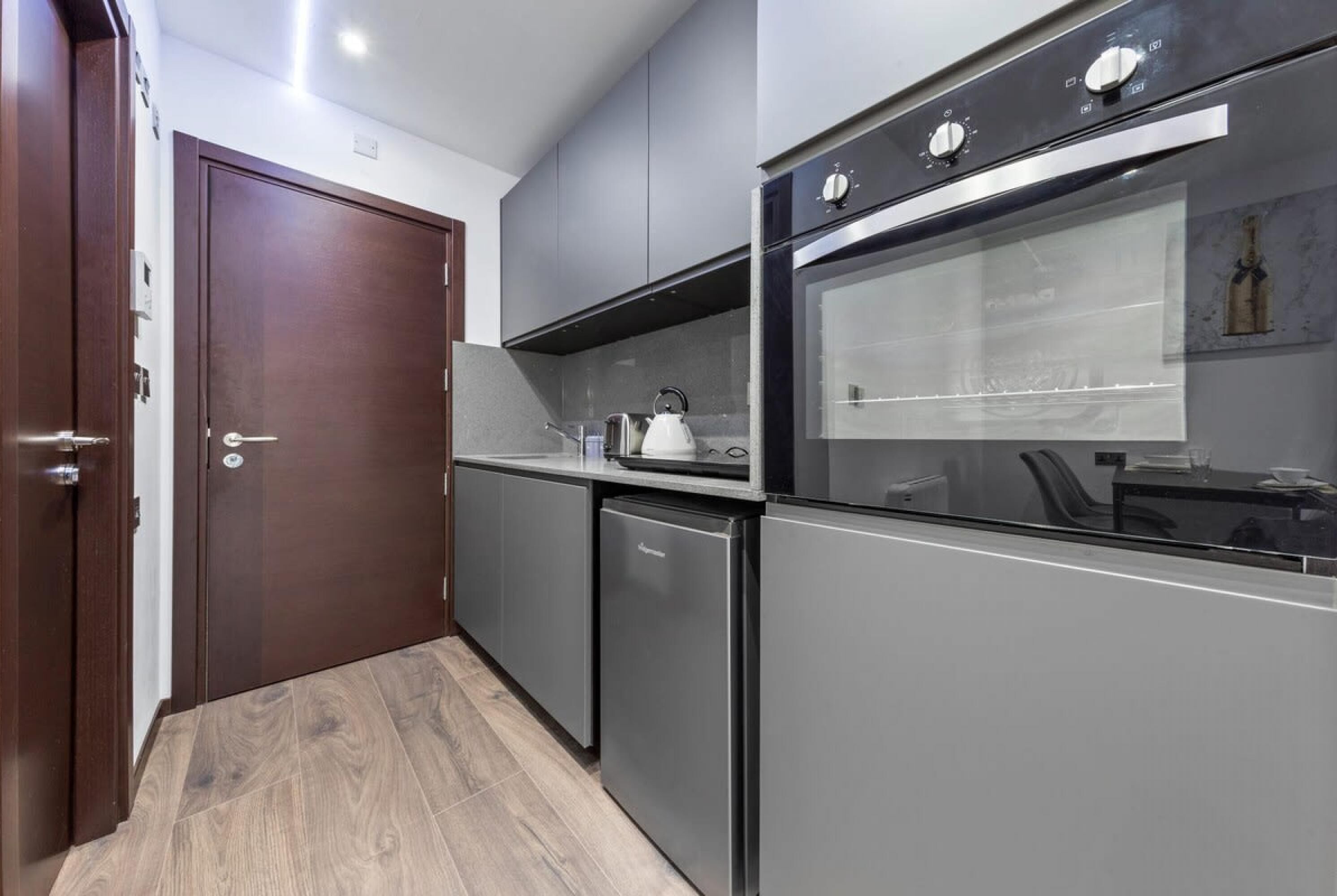 A modern kitchen with a built-in oven, a coffee machine, and a dishwasher.